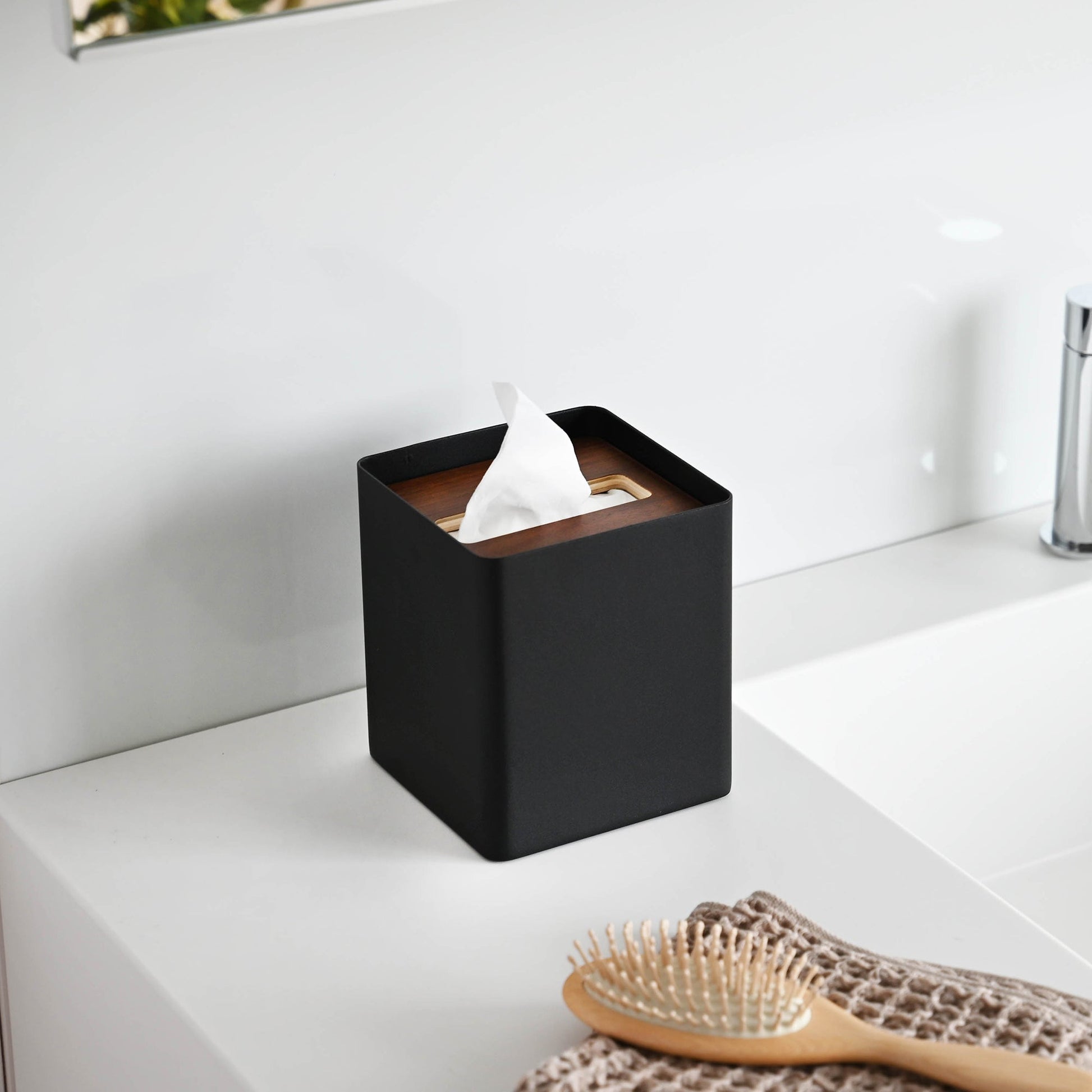 Side view of black Tissue Case on bathroom sink countertop by Yamazaki Home.
