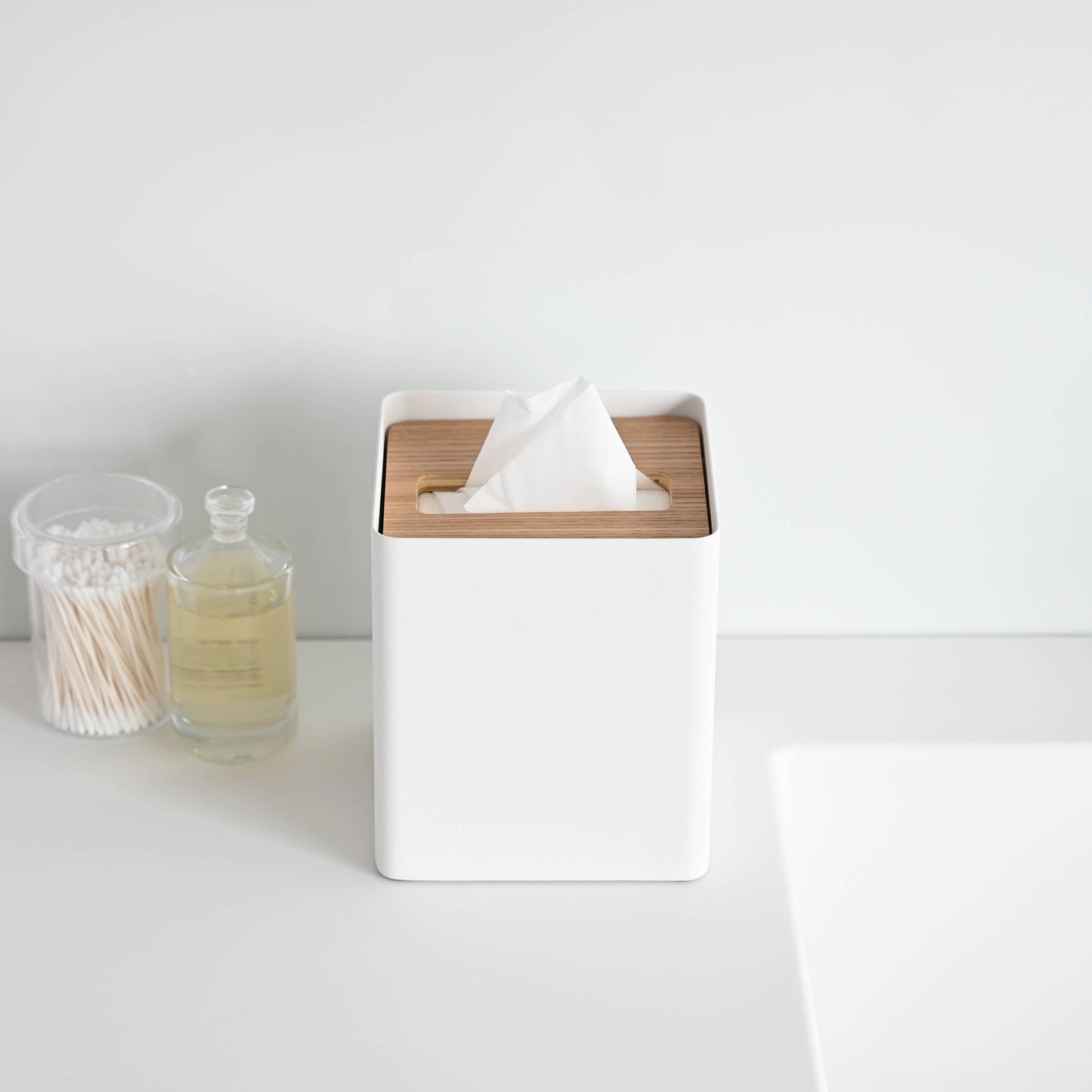 Front view of white Tissue Case on sink countertop by Yamazaki Home.