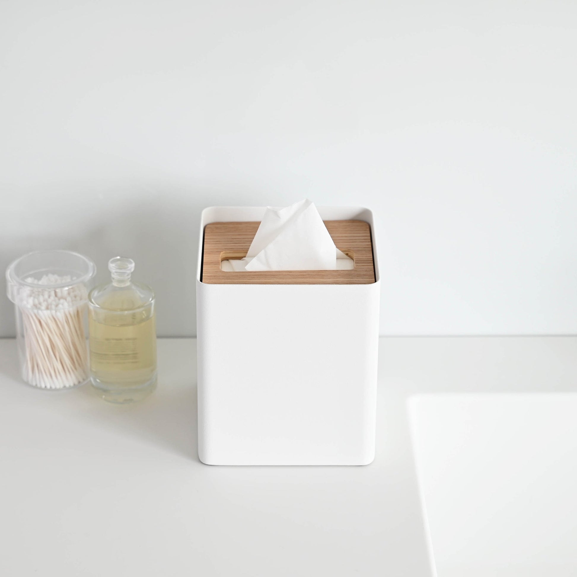Front view of white Tissue Case on sink countertop by Yamazaki Home.