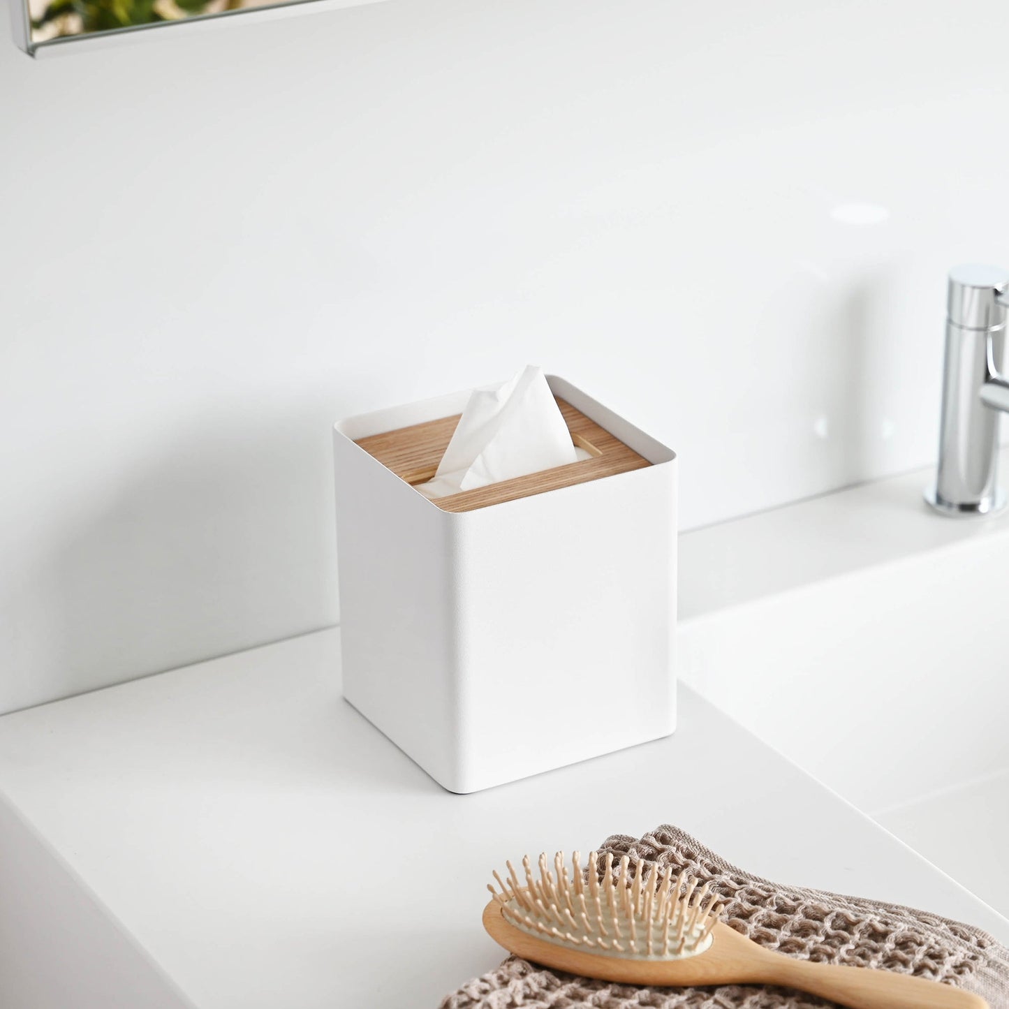 Side view of white Tissue Case on bathroom sink countertop by Yamazaki Home.