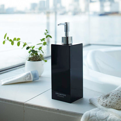 Black Yamazaki Home square shampoo dispenser by bathtub