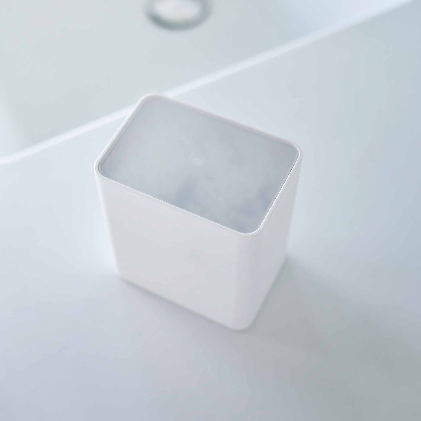 Top view of the cotton swab push-top case with the lid on from Yamazaki Home in white.