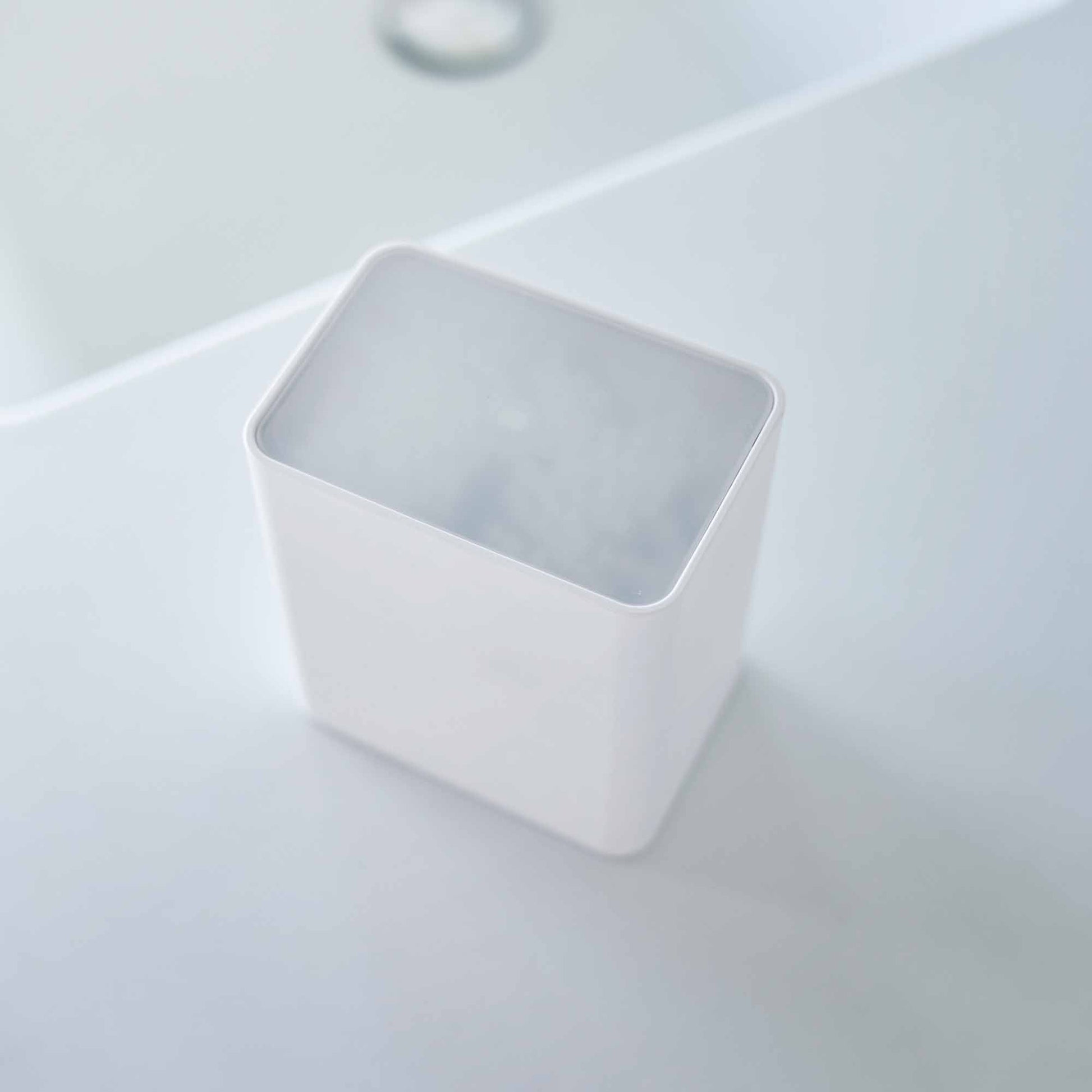 Top view of the cotton swab push-top case with the lid on from Yamazaki Home in white.