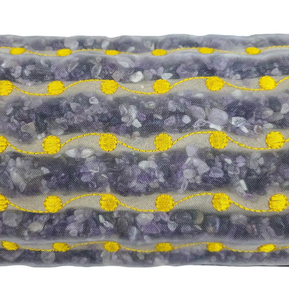 Close-up of amethyst stones and yellow wavy embroidery on heated bolster