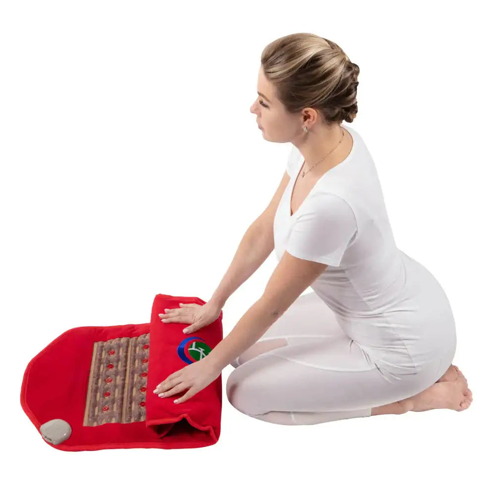 Woman rolling up red HealthyLine infrared heating mat to reveal brown textured LED surface