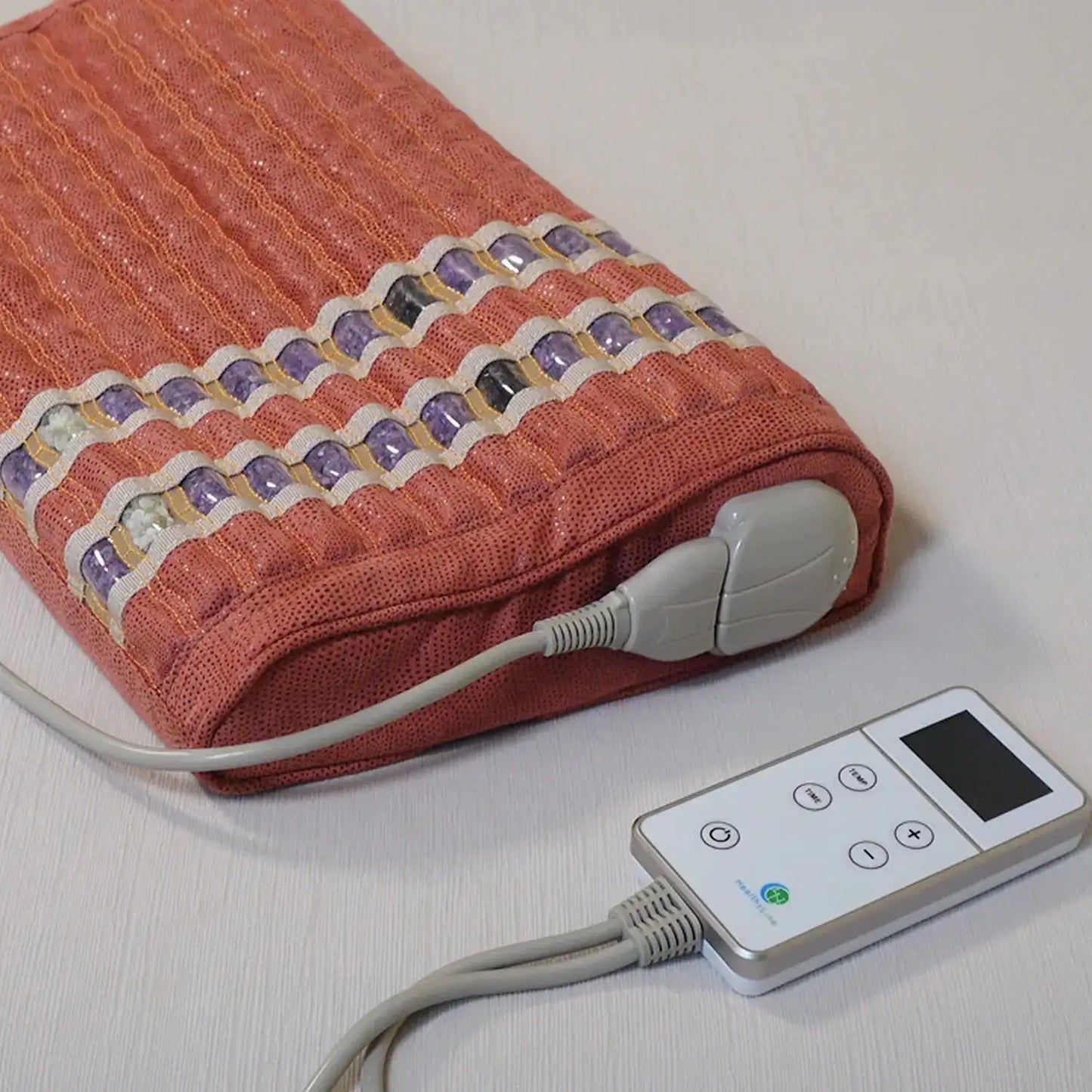 Coral textured heated cushion with remote control and gemstone rows