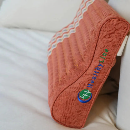 Side view of HealthyLine contoured pillow on bedsheet with logo