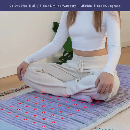 Person using purple textured HealthyLine PEMF infrared therapy mat with glowing red lights for relaxation