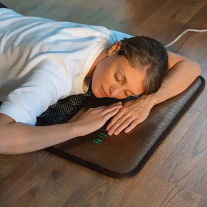 Person using HealthyLine mesh heating pad for back relaxation on floor