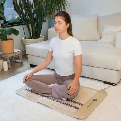 Woman practicing yoga meditation on HealthyLine SOFT FAR infrared heating mat with gemstone rows