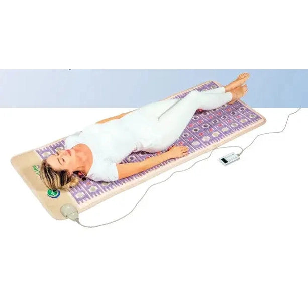 Woman using HealthyLine TAJ-Mat PEMF infrared heating mat for full-body relaxation