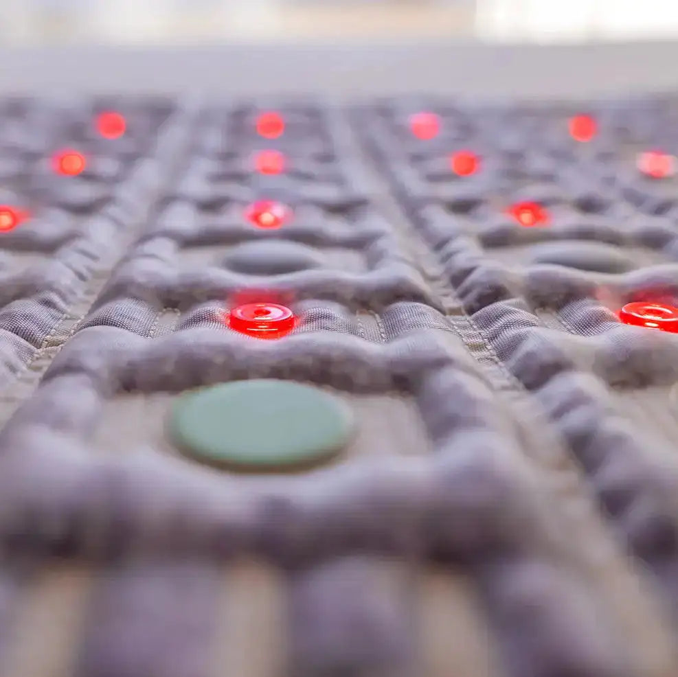 Macro view of HealthyLine TAJ mat textured purple fabric and embedded red green discs