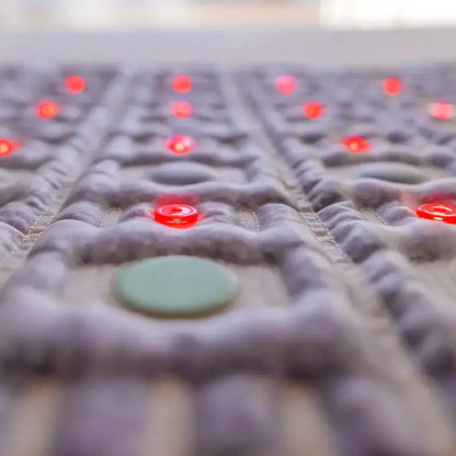 Macro view of HealthyLine TAJ mat textured purple fabric and embedded red green discs