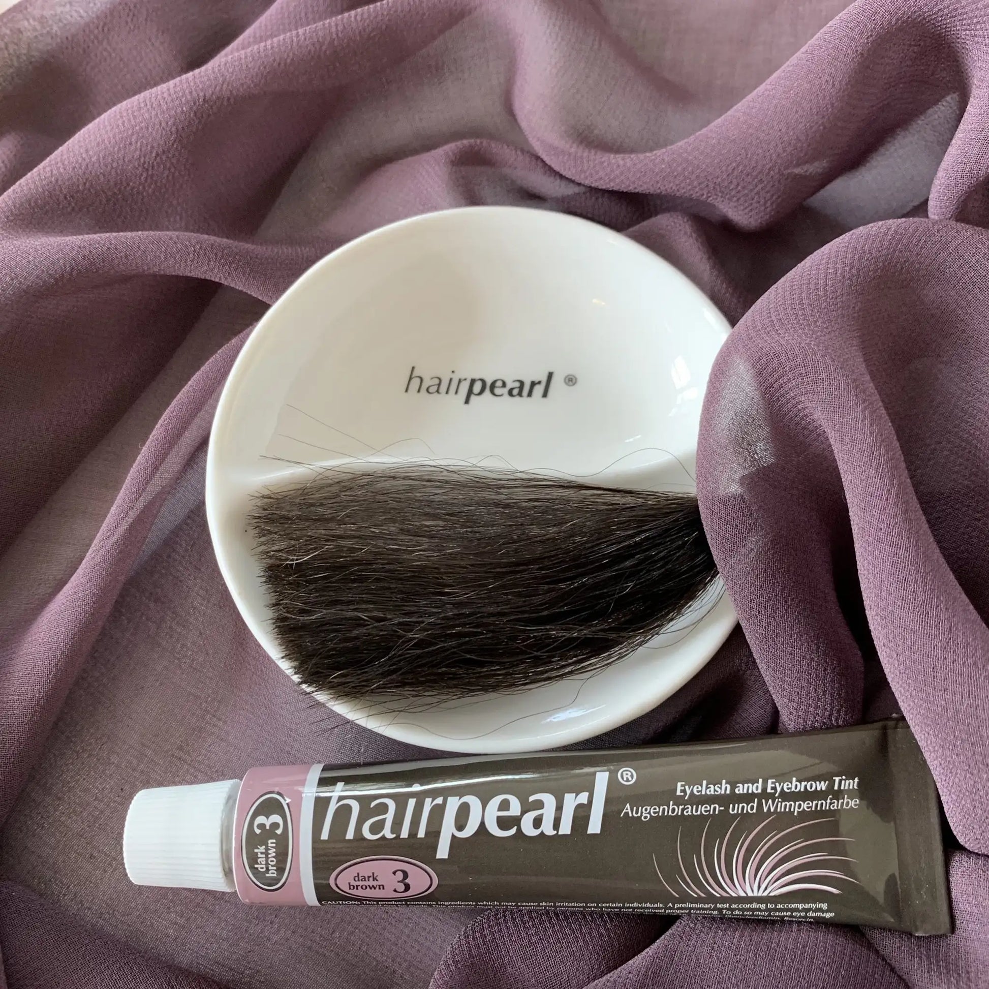 Hairpearl dark brown lash and brow tint flat lay with hair sample