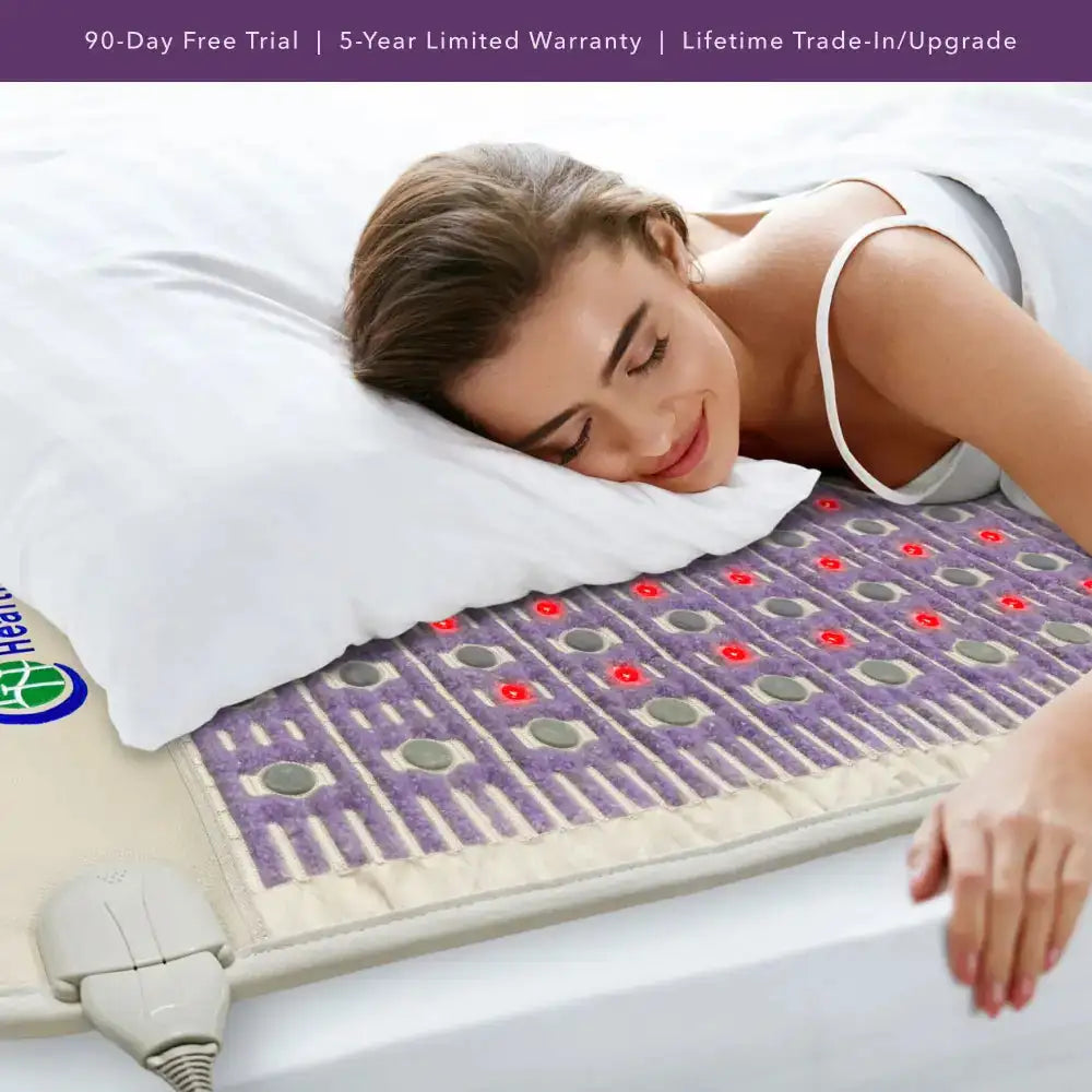 Woman sleeping on HealthyLine TAJ PEMF mat with control unit and warranty banner