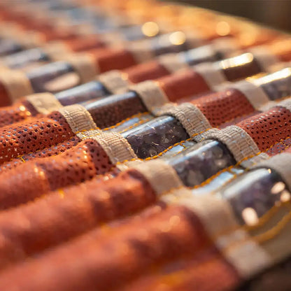 Close-up of purple crystalline gemstone core inside orange fabric heating mat sleeve
