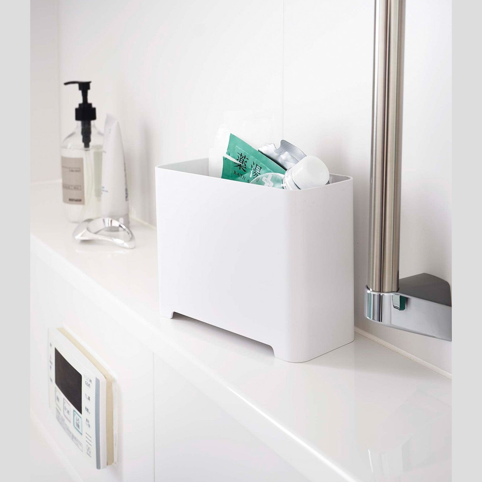 White Yamazaki Self-Draining Bathroom Organizer filled with bath supplies