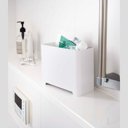 White Yamazaki Self-Draining Bathroom Organizer filled with bath supplies