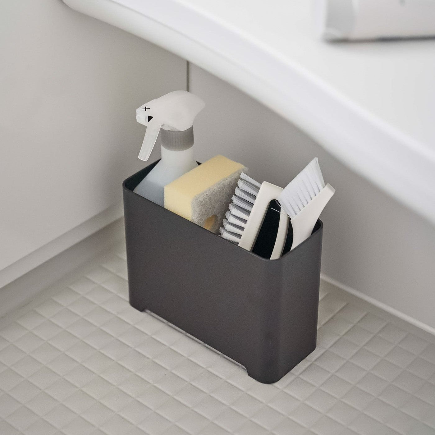 Black Yamazaki Self-Draining Bathroom Organizer filled with cleaning supplies