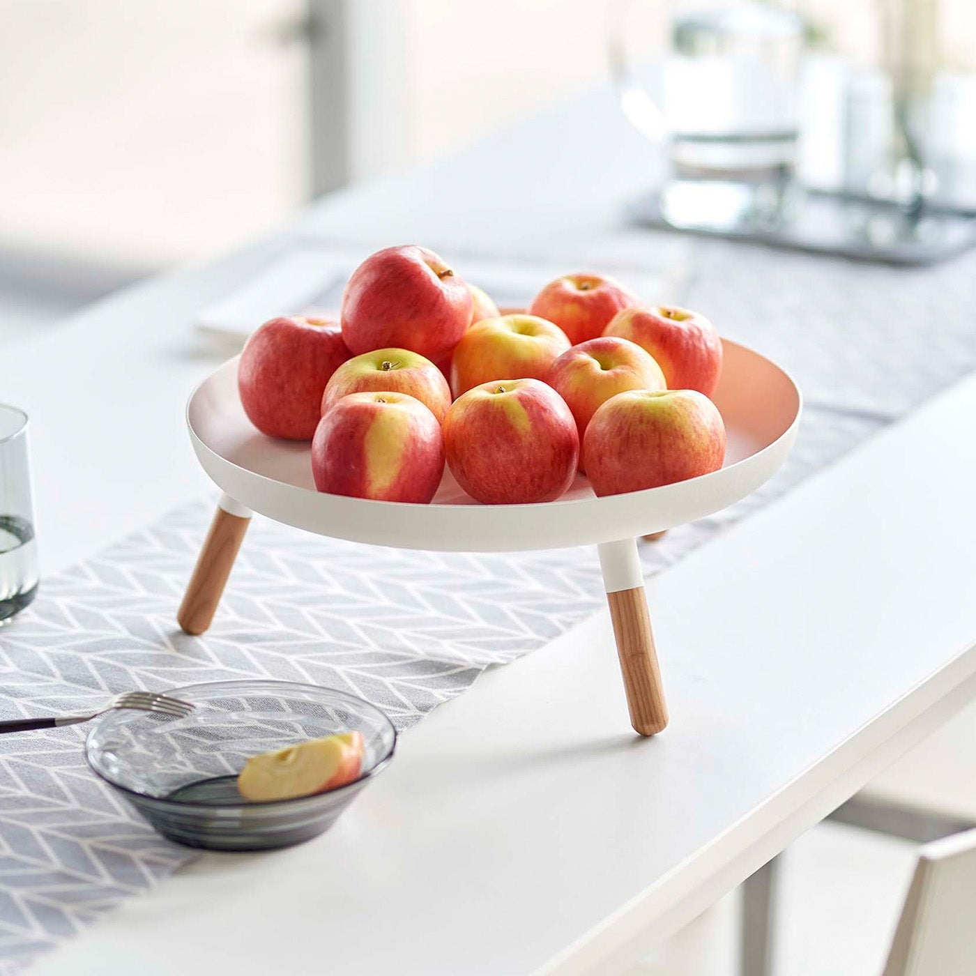 White Yamazaki Countertop Pedestal Tray with apples on top on a dining table