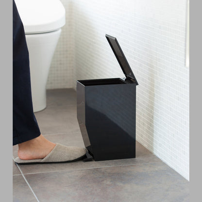 Side view of black Step Trash Can open in bathroom by Yamazaki Home.