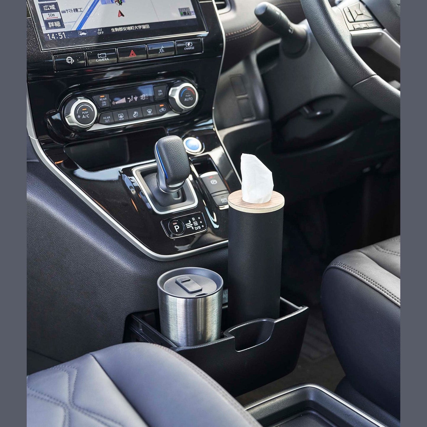 Small black Yamazaki Home Round Tissue Case in the center console cup holder of a car