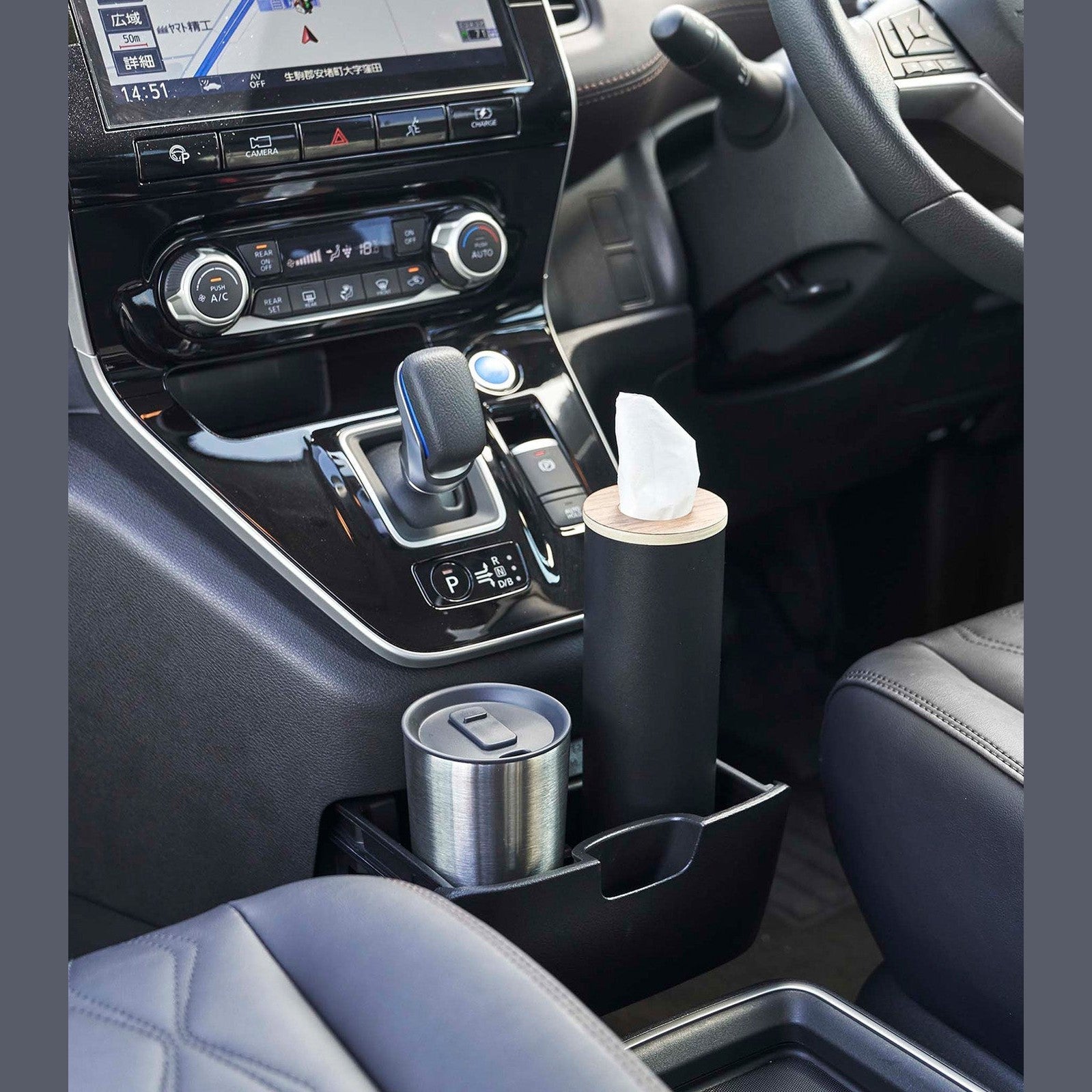Small black Yamazaki Home Round Tissue Case in the center console cup holder of a car