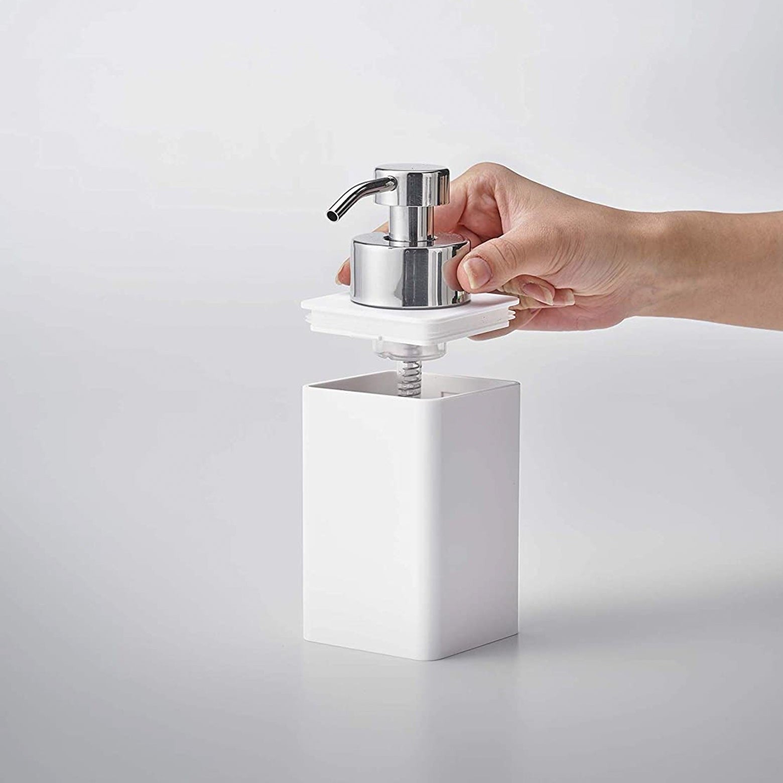White Foaming Soap Dispenser with top removed on white background by Yamazaki Home.