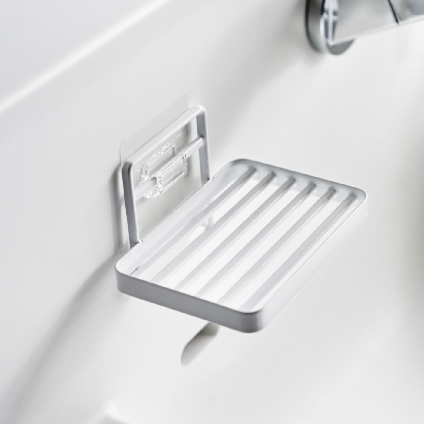 Yamazaki Home's black Traceless Adhesive Soap Tray mounted on a bathroom wall.