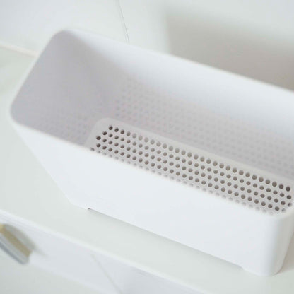 Close up of draining holes of white Yamazaki Self-Draining Bathroom Organizer
