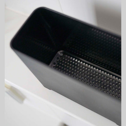 Close up of draining holes of black Yamazaki Self-Draining Bathroom Organizer