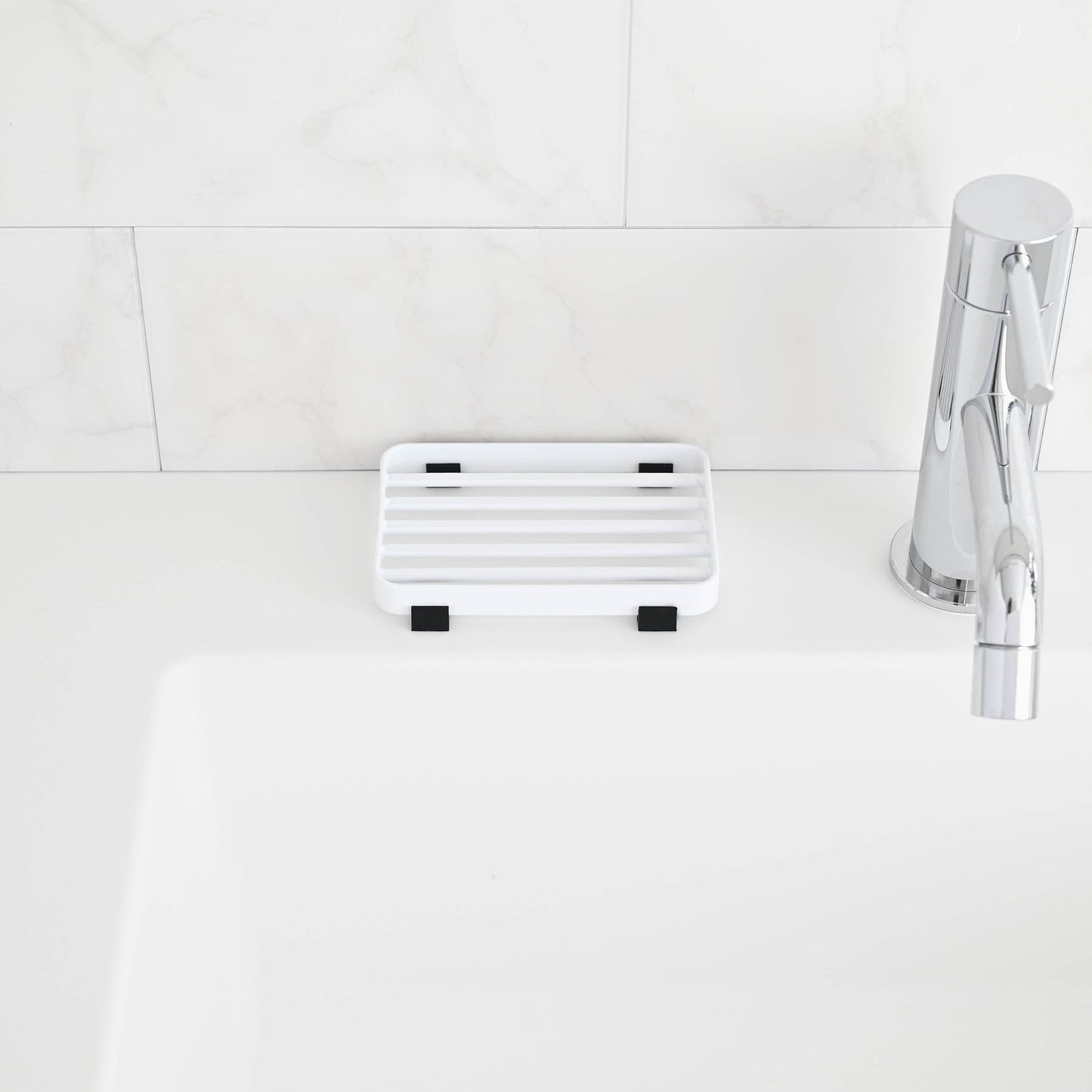 Front view of White Slotted Soap Tray on bathroom countertop by Yamazaki Home.