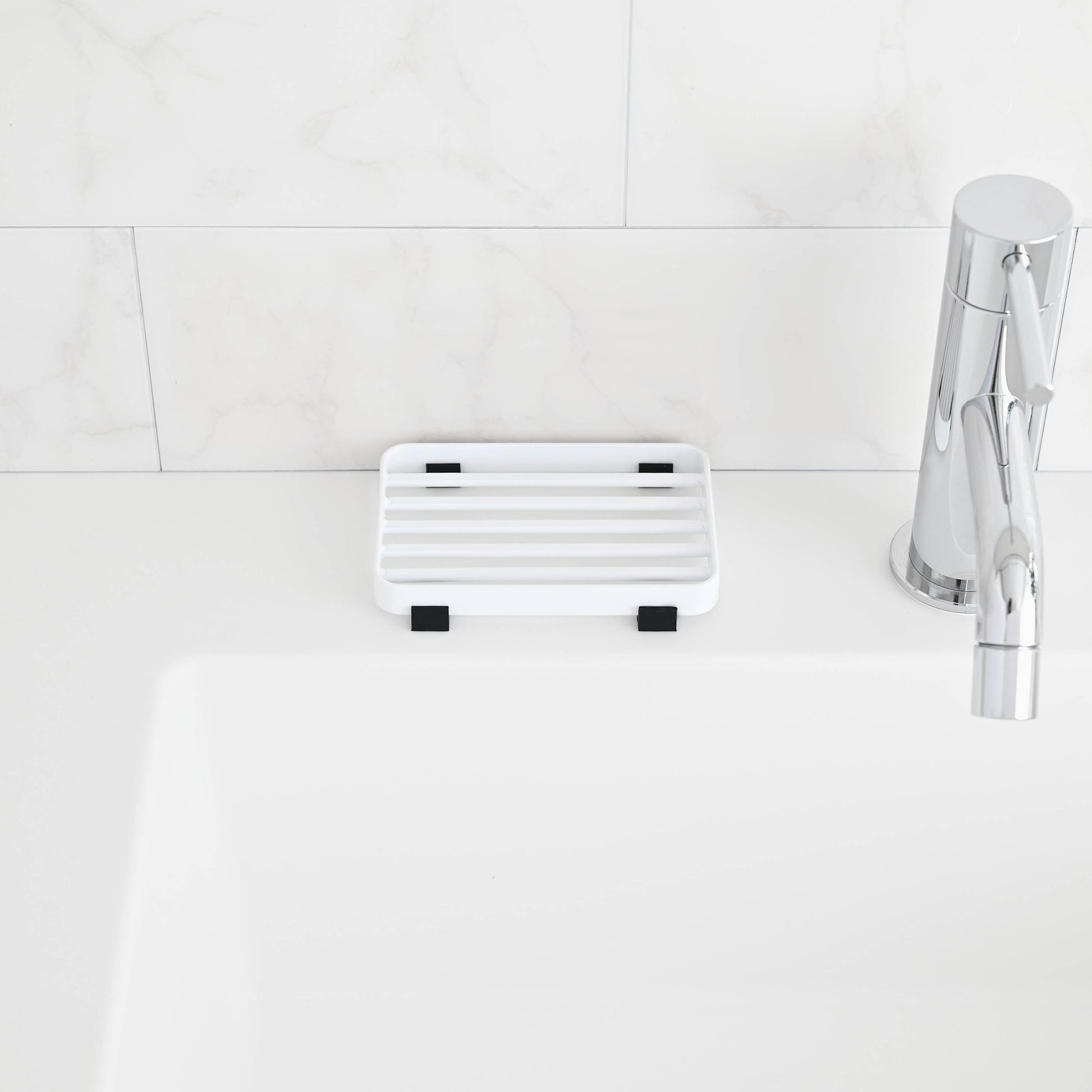 Front view of White Slotted Soap Tray on bathroom countertop by Yamazaki Home.