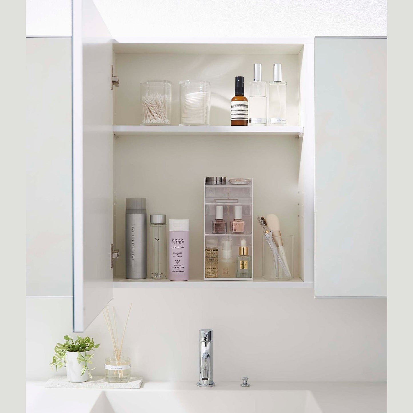 A white medicine cabinet is open to display the inside contents. Sunlight is focused on the right upper corner. Below is a bathroom sink.