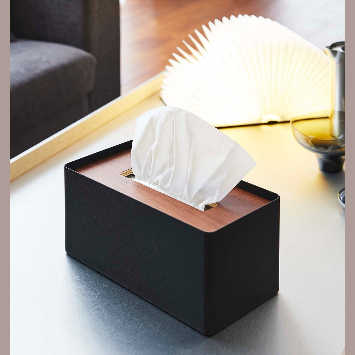 Black Tissue Case on coffee table next to book light by Yamazaki Home.