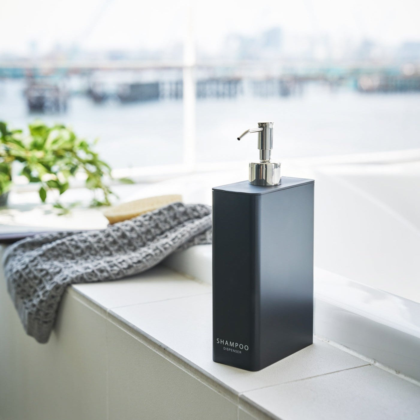 Black Shampoo Dispenser in bathroom by Yamazaki Home.