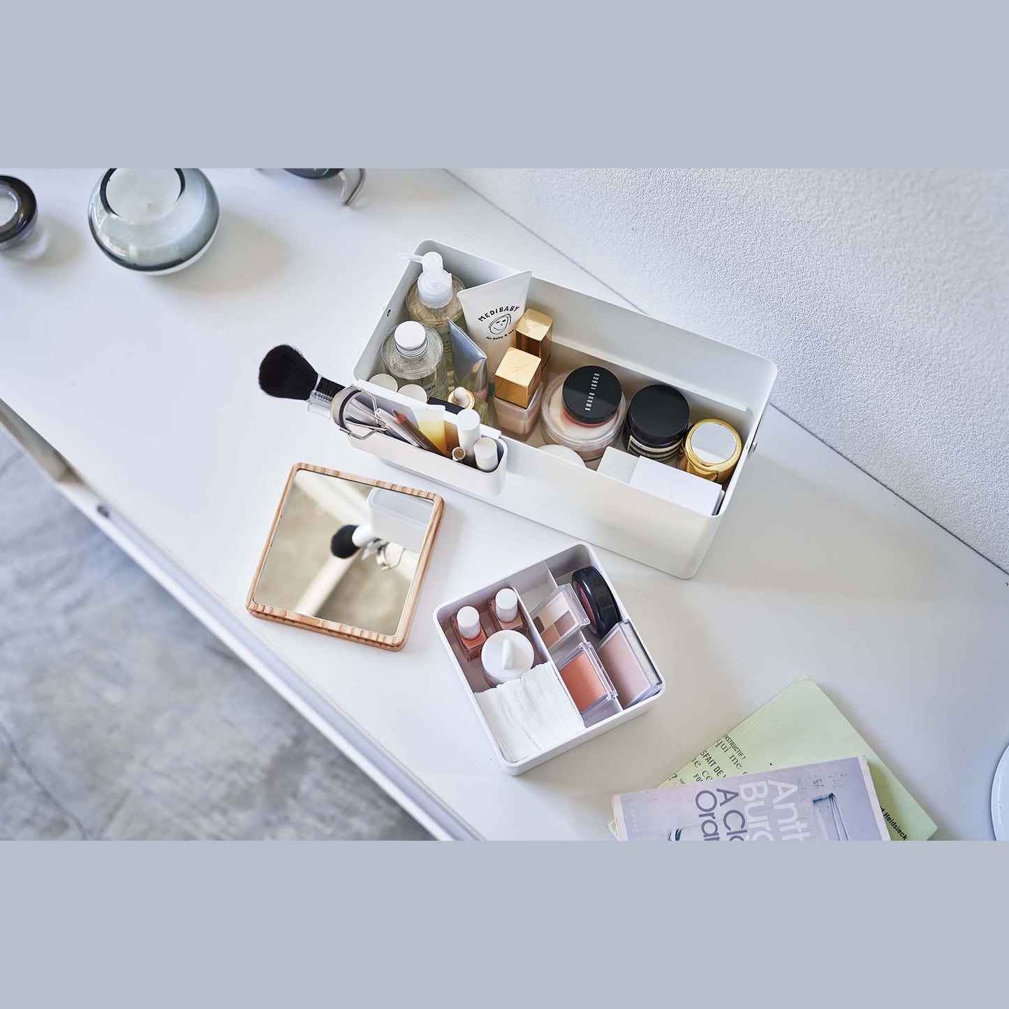 Aerial view of open white Makeup Organizer and comparments holding makeup products on table by Yamazaki Home.