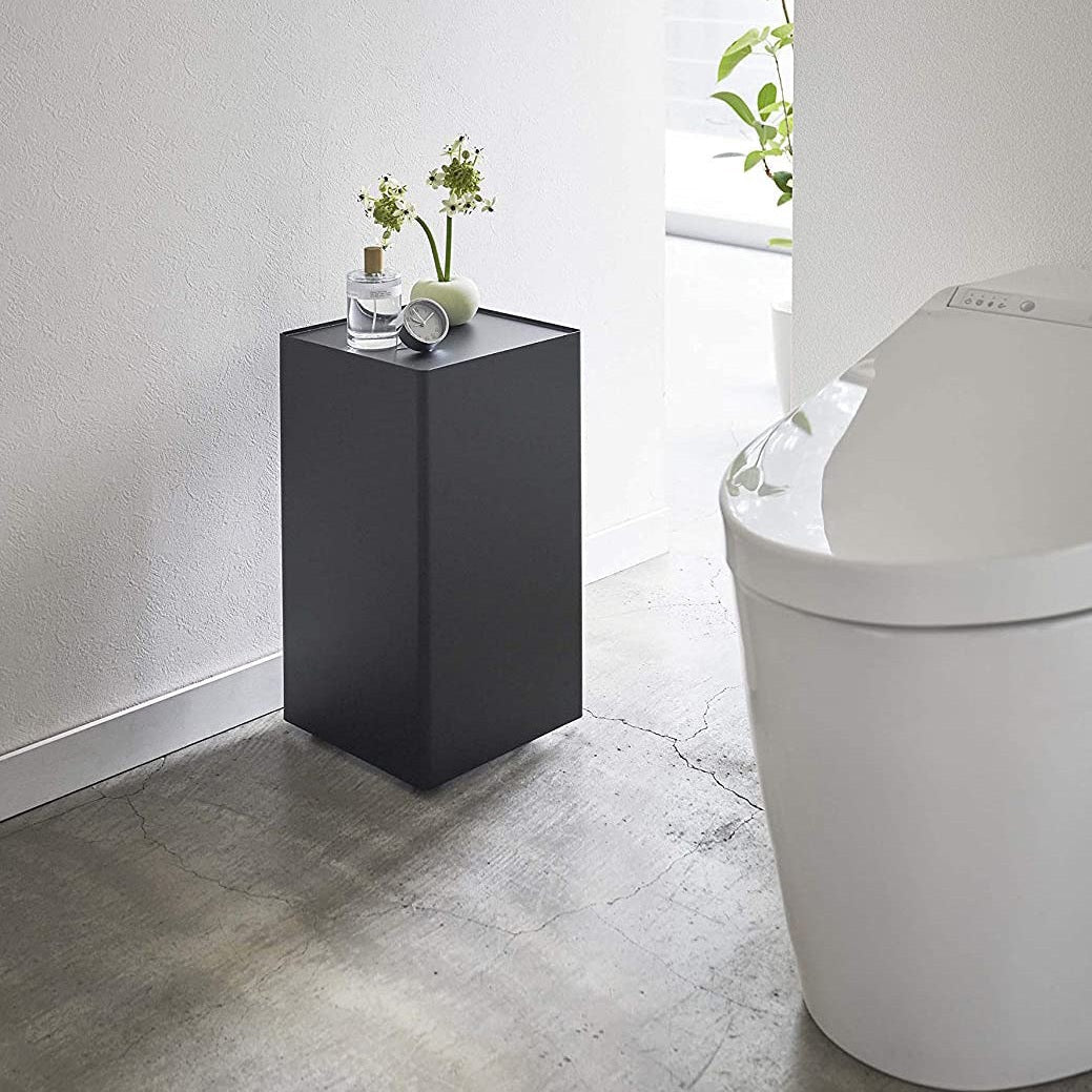 Black Rolling Bathroom Organizer with dÃÂ©cor on top in bathroom by Yamazaki Home.