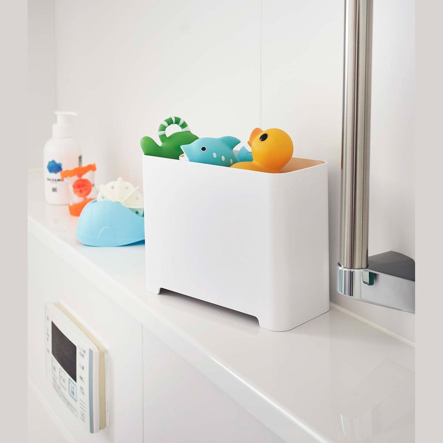 White Yamazaki Self-Draining Bathroom Organizer filled with bath toys
