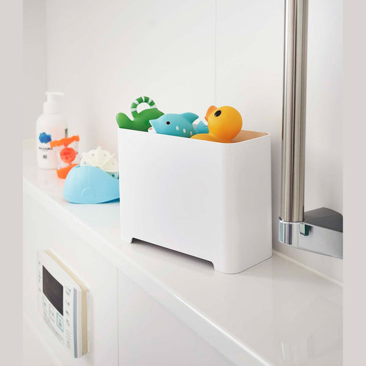 White Yamazaki Self-Draining Bathroom Organizer filled with bath toys