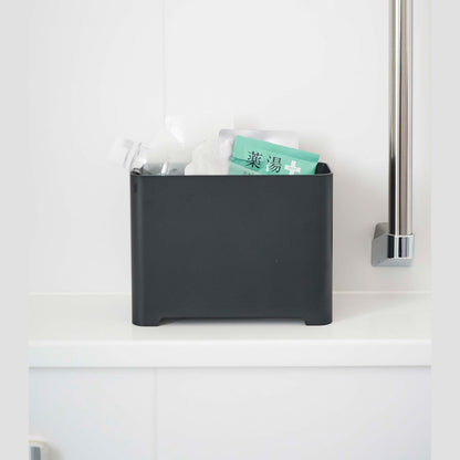 Frontal view of black Yamazaki Self-Draining Bathroom Organizer filled with bath supplies