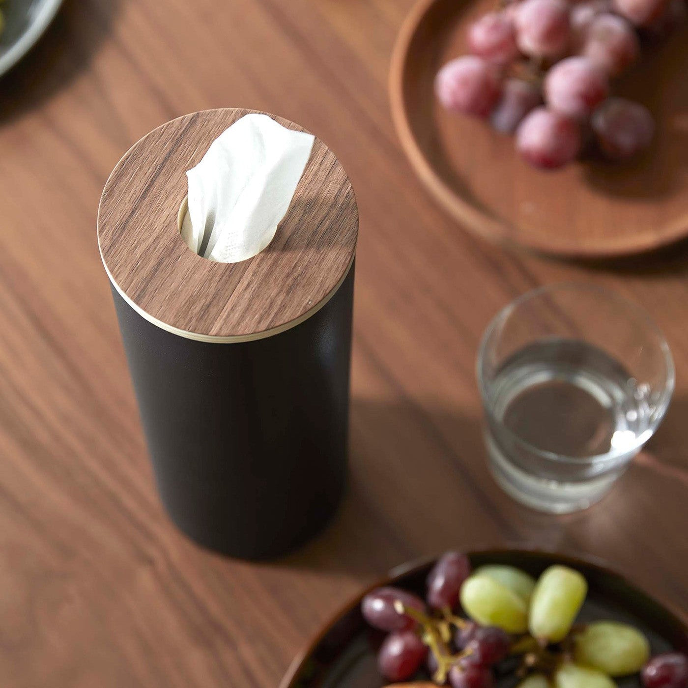 Close up of Large black Yamazaki Home Round Tissue Case on a dining table