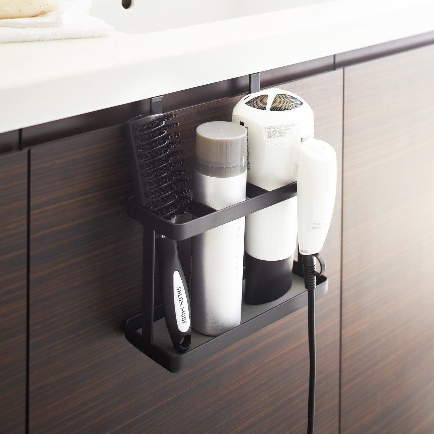 Black Haircare Appliance Holder holding hot tools and brush in bathroom by Yamazaki Home.