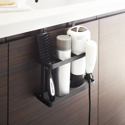 Black Haircare Appliance Holder holding hot tools and brush in bathroom by Yamazaki Home.