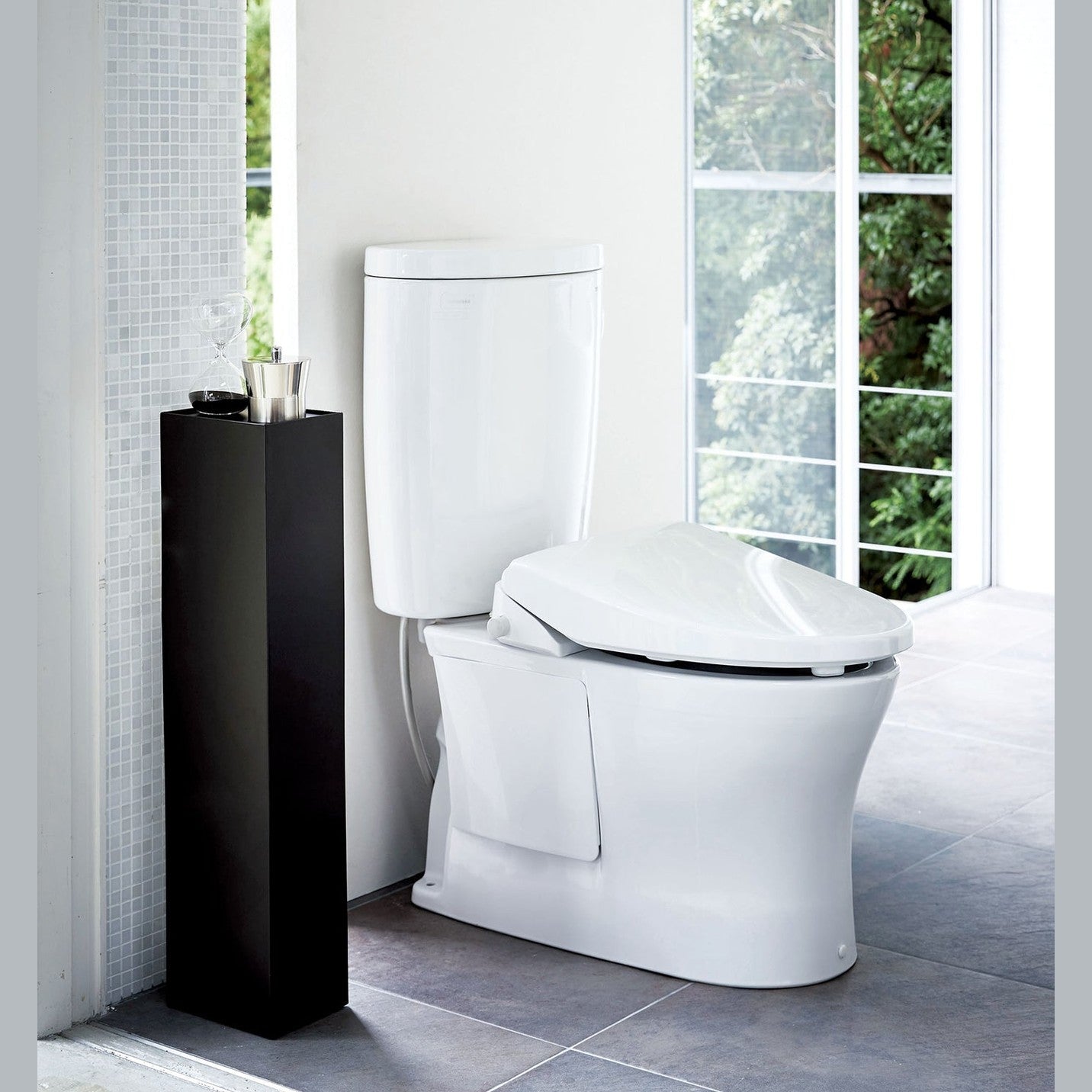 Yamazaki Home black Toilet Organizer holding decor pieces in bathroom.