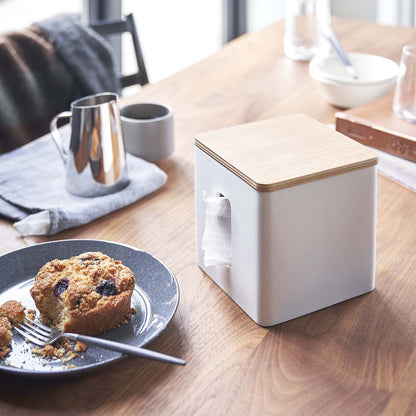 White toilet paper holder on tabletop by Yamazaki Home.