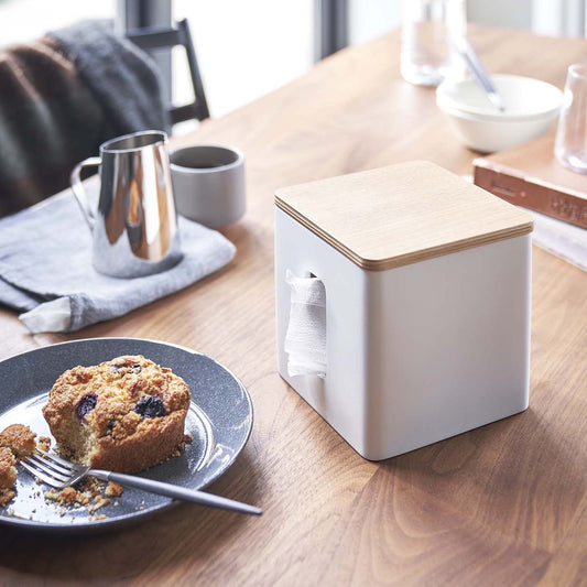White toilet paper holder on tabletop by Yamazaki Home.