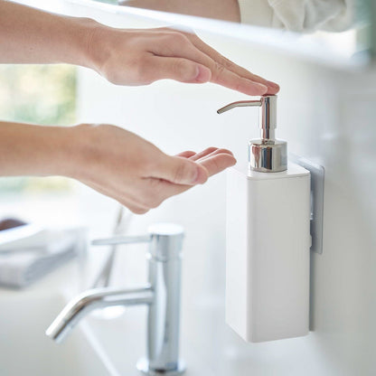 Dispensing soap from white Yamazaki Home square soap onto hands