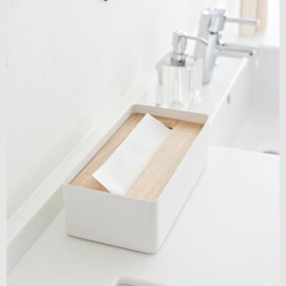 Aerial side view of white Tissue Case on bathroom sink counter by Yamazaki Home.