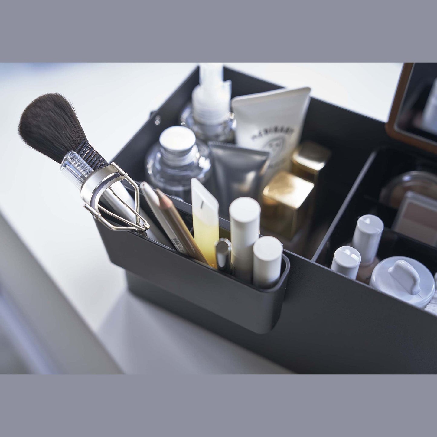 Close up aerial view of black Makeup Organizer containing makeup products by Yamazaki Home.